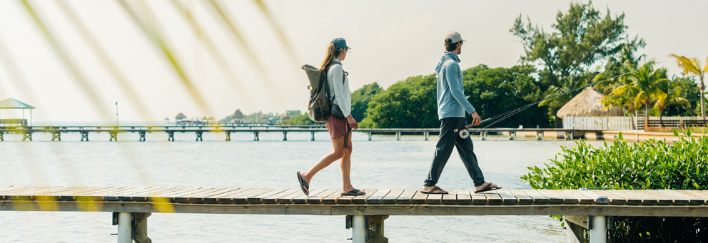 Man and woman walking along a pier in UPF apparel