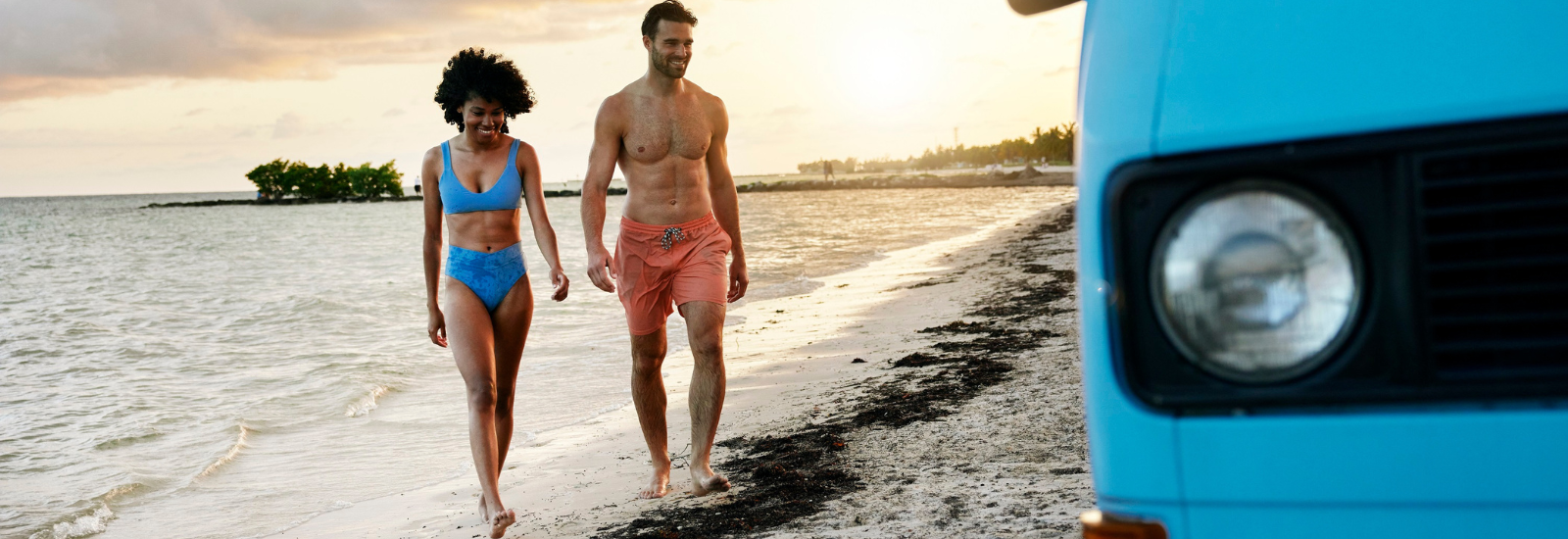 Man and woman walking in from the beach together on a cloudy day