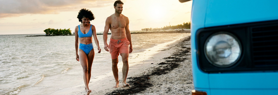 Man and woman walking in from the beach together on a cloudy day